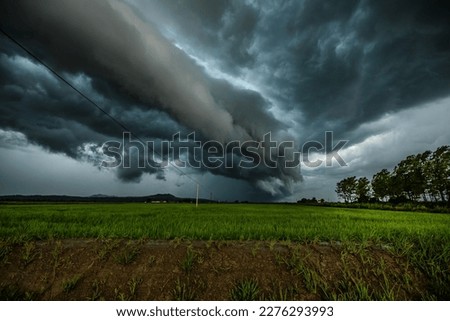 Terrifying severe supercell thunderstorm clouds rolling in over the countryside. 