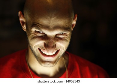 Terrifying Terrorist. A Scary Man Looking At The Camera With Face Lighted From Under His Chin And With A Grin As A Smile. Look Into My Portfolio For A Not Smiling Version