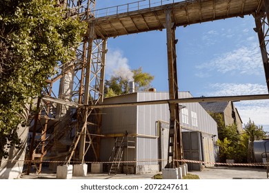 Territory Of Manufacturing Plant With Industrial Buildings And Equipment Against Blue Sky