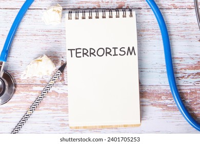TERRORISM text is written on a notebook that lies on old vintage boards