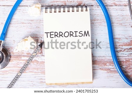 TERRORISM text is written on a notebook that lies on old vintage boards