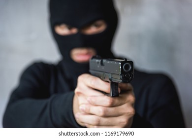 Terrorist Or Burglar In Black Mask Shooting The Gun Aiming, Robber Concept