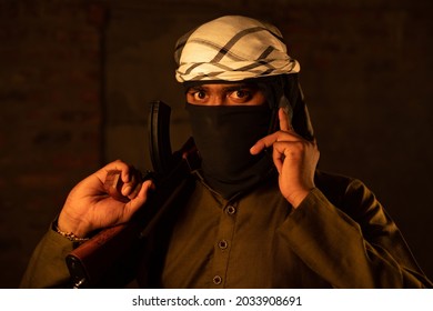 Terrorist Or Gangster With Face Cover Blackmailing Or Asking For Ransom Over Mobile Phone Call And Warning By Showing Gun