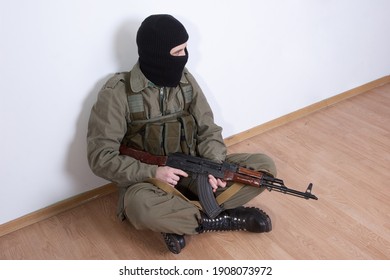 Terrorist With Kalashnikov Gun Sitting Near The Wall