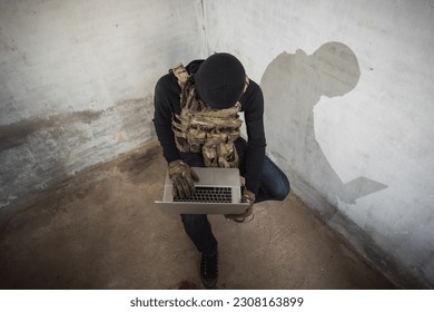 Terrorist man cyber hacker hacking internet to access steal information by laptop computer, robber criminal concept