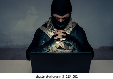 Terrorist working on his computer. Concept about international crisis, war and terrorism