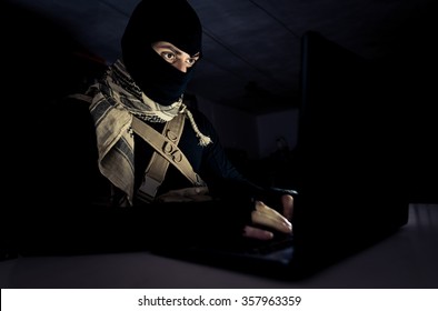 Terrorist working on his computer. Concept about international crisis, war and terrorism