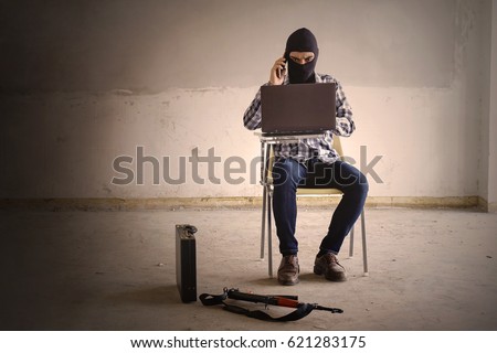 Terrorist working on his computer. Concept about international crisis, war, terrorism ,terrorist andbandit