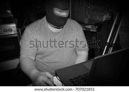 Terrorist working on his computer. Concept about international crisis, war, terrorism ,terrorist and bandit