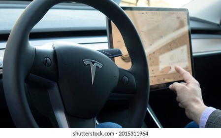 TESLA CAR, RUSSIA, April 2021: A Person Sitting In An Autonomous Tesla Car Adjusts Navigation On The Touch Console In His Autonomous Car.