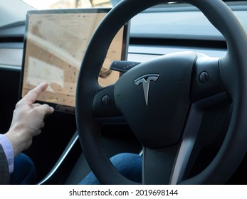 TESLA CAR, RUSSIA, April 2021: A Person Sitting In An Autonomous Tesla Car Adjusts Navigation On The Touch Console In His Autonomous Car.