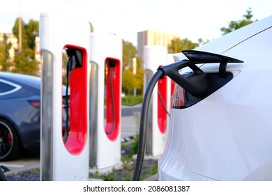 Tesla light electric cars replenish battery at charging station, alternative energy development concept, electric vehicle production