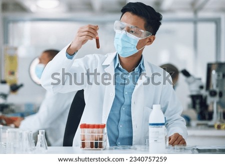 Test, blood sample and scientist doing research with face mask in a laboratory for medical analysis in a lab. Science, medicine and professional Asian man working on exam of DNA in a vial tube
