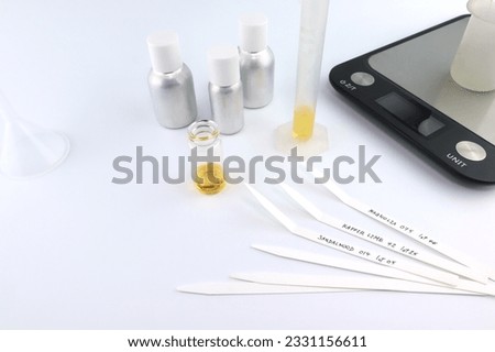 test blotter papers on white table with digital scale, essential oil ,frangrance oil bottle for testing smell during blending process for choosing nice scent for scented candle and body perfume in lab