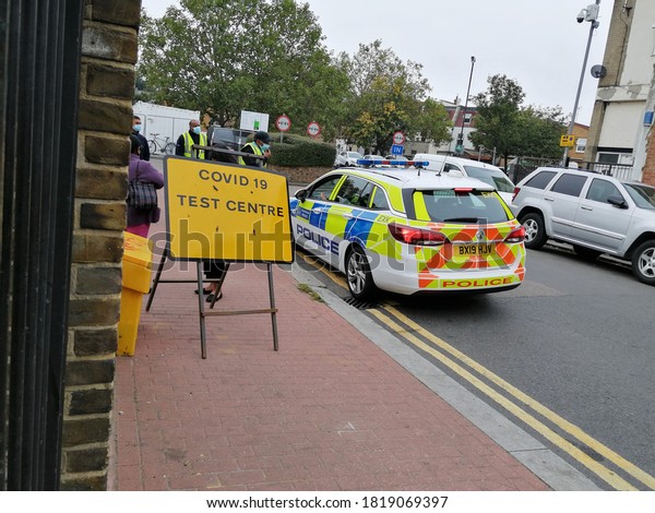 Test Centre covid 19, London, UK - 21.9.2021:\
Covid-19 coronavirus test or testing centre road sign  in North\
London with police car