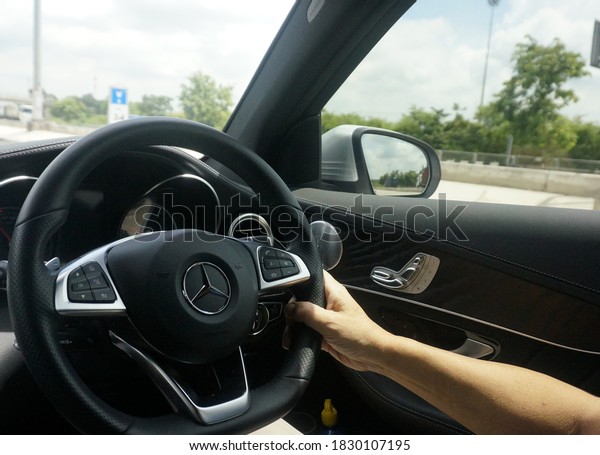 Test driving, on 2020 September 24, a man\'s hand\
 holding a car steering wheel; BENZ on Mitraphap Road heading from\
Bangkok to Ayuttaya\
Province