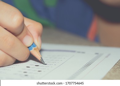 Test Exam Student Kid, Pencil Writing Answer On Paper Answer Of Question In Examination Test. It Assessment Intended To Measure Knowledge, Skill, Aptitude, Physical Fitness, Or Classification Students