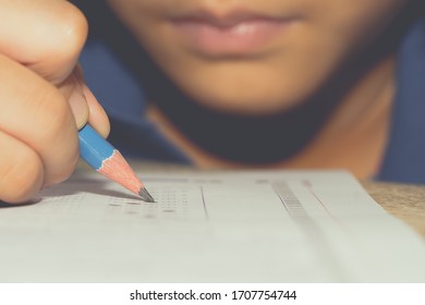 Test Exam Student Kid, Pencil Writing Answer On Paper Answer Of Question In Examination Test. It Assessment Intended To Measure Knowledge, Skill, Aptitude, Physical Fitness, Or Classification Students