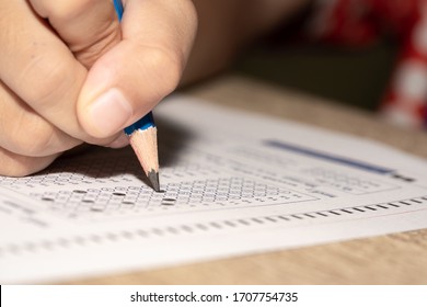 Test Exam Student, Pencil Writing Answer On Paper Answer Of Question In Examination Test. It Assessment Intended To Measure Knowledge, Skill, Aptitude, Physical Fitness, Or Classification Students