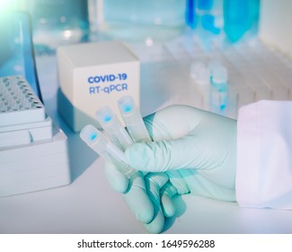 Test kit to detect novel COVID-19 coronavirus in patient samples. RT-PCR kit reagents convert viral Covid19 RNA to DNA and amplify specific region of 2019-nCov. Hand in glove holding test tubes.