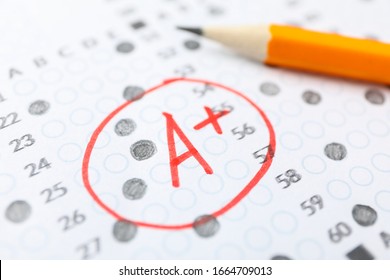 Test score sheet with answers, grade A+ and pencil, close up - Shutterstock ID 1664709013