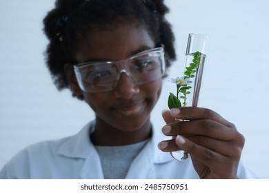 Test tube with green green leaf plant be hold by curly haired black skinned young scientist girl at biotechnology laboratory.African american teenage study science in lab. - Powered by Shutterstock