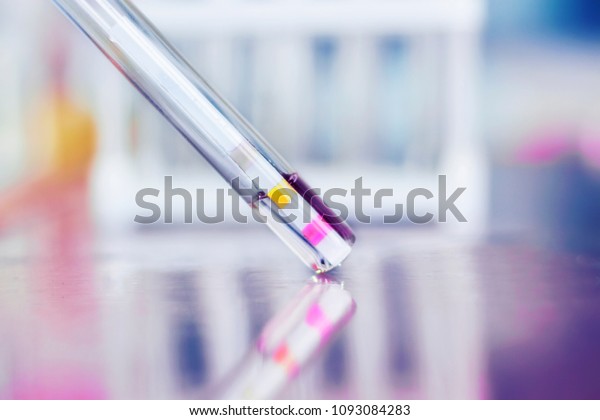 Test tube with an indicator strip on a light\
blurry background.