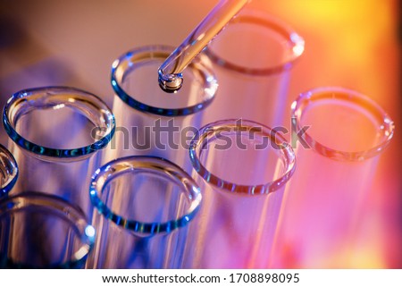 Test tube row. Concept of medical or science laboratory, liquid drop droplet with dropper in blue red tone background, close up, macro photography picture. Stockfoto © 