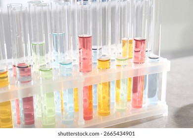 Test tubes with different samples on grey table in laboratory, closeup. Solution chemistry