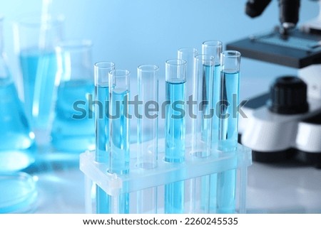 Test tubes with light blue liquid in laboratory, closeup