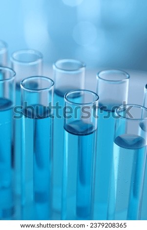 Test tubes with light blue liquid in laboratory, closeup