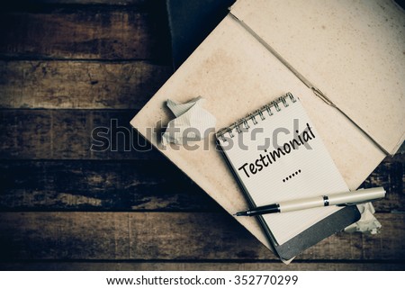 Testimonial word on pages sketch book on wood table vertical 