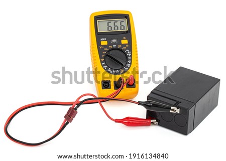 Testing an acid rechargeable battery with a measuring instrument isolated on white background