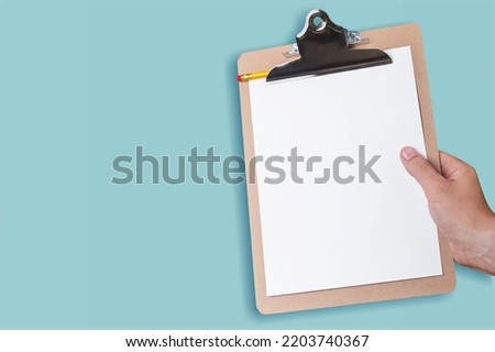 Testing System concept. Hands hold a paper on clipboard.