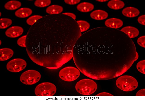 Testosterone boost\
increase, improve fertility, masculine bro science and recovery\
balls tanning concept with two eggs on a red light therapy\
spotlight lamp in a dark\
room
