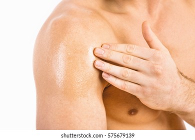 Testosterone Replacement Therapy (TRT) - Muscular man applying testosterone gel on shoulder