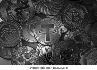 Tether USDT, Bitcoin and other altcoins cryptocurrency physical coins placed on top of each other and lit with selective lights.