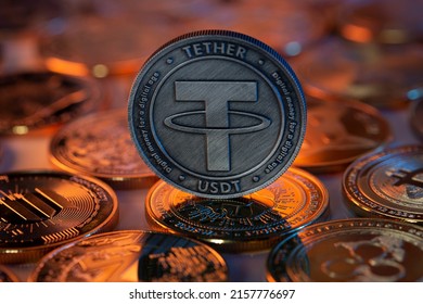 Tether USDT Cryptocurrency Physical Coin placed on crypto altcoins and lit with orange and blue lights in the dark Backgrond. Macro shot. Selective focus. - Shutterstock ID 2157776697