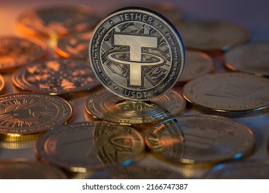 Tether USDT Cryptocurrency Physical Coin placed on crypto altcoins and lit with orange and blue lights in the dark Backgrond. Macro shot. Selective focus. - Shutterstock ID 2166747387