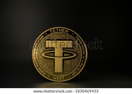 TETHER USDT cryptocurrency physical coin placed on the table in the dark background. Macro Shot.