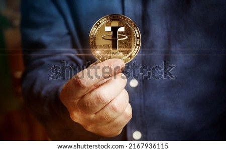 Tether USDT stablecoin cryptocurrency golden coin in hand abstract concept