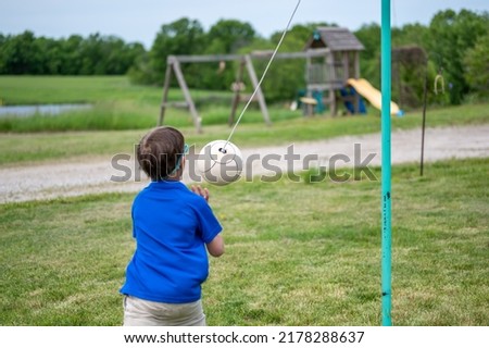 Tetherball being hit and roped in a game with a young boy. 