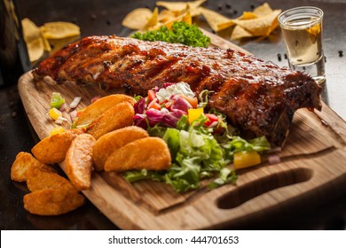 tex mex porc ribs with potatoes and salad as served in a restaurant