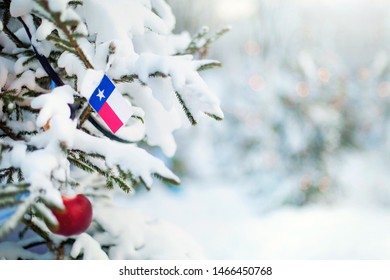 Texas flag. Christmas tree branch with a flag of Texas state. Xmas holidays greetings card. Winter landscape outdoors.