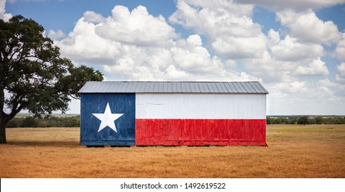 Texas flag painted on old barn. American farmers background, rural scene.