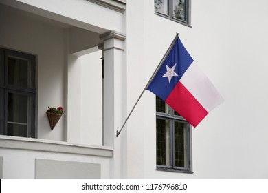 Texas Flag. Texas State Flag Hanging On A Pole In Front Of The House. State Flag Waving On A Home Displaying On A Pole On A Front Door Of A Building. Flag Raised At A Full Staff.