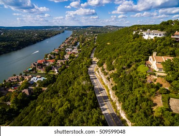 Texas Hill Country,  Mount Bonnell. Road to Texas aerial Shot over Austin , Texas. Windy road and Houses along the Colorado River or Town Lake with boats driving across the water in Austin , Texas 