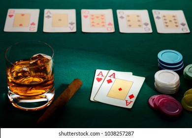 Texas hold'em poker with a hand of two aces, chips, cigar, and glass of whiskey on green broadcloth. Won by three aces. - Powered by Shutterstock