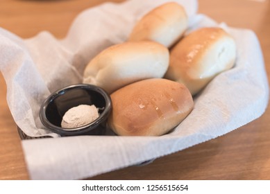 Texas Roadhouse Rolls With Cinnamon Honey Butter In A Basket.