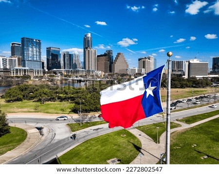 Texas State flag flying over the capital city of Texas in front of Austin Texas USA Skyline Cityscape 